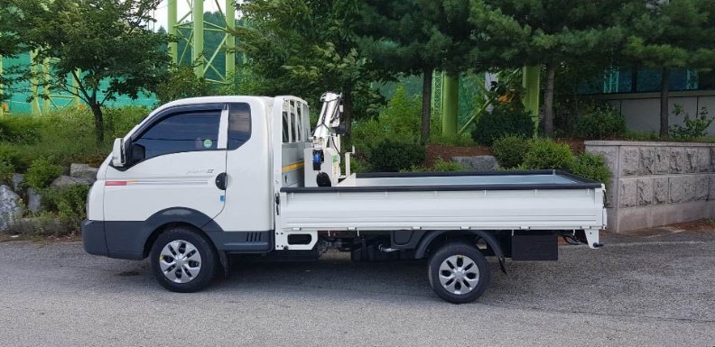 흰색 화물차에 장착해 붐을 접은 소형 크레인